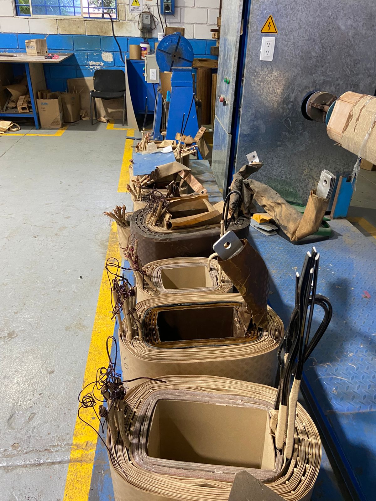 Banco de trabajo con bobinas de transformador en proceso de rebobinado